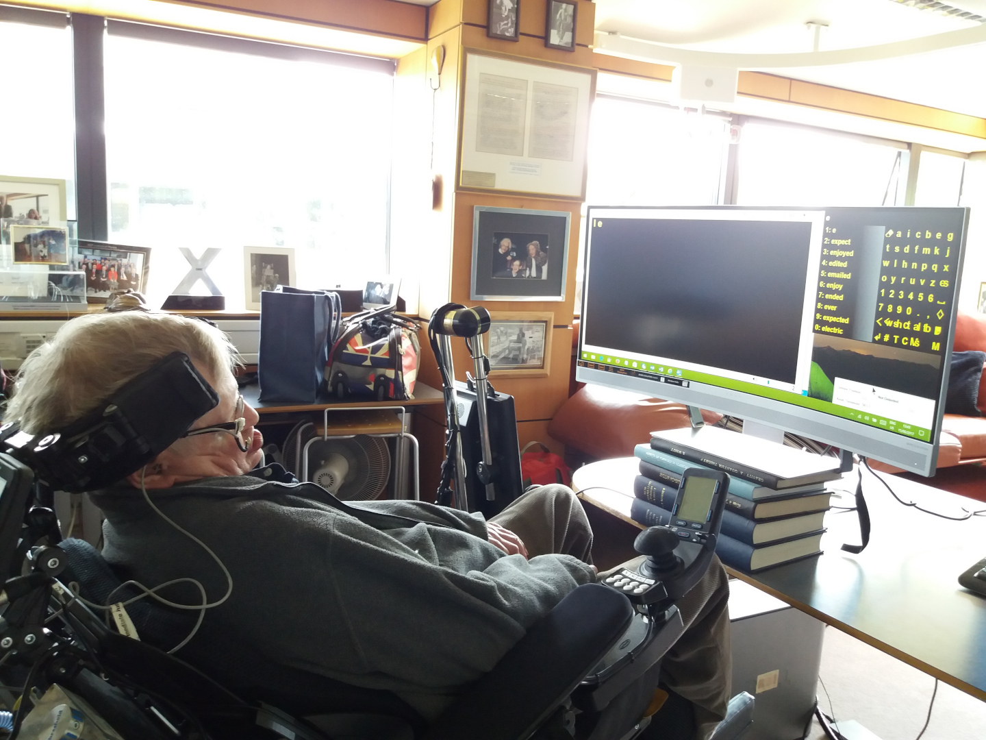Screenshot of the ACAT software interface showing the text editor, word prediction, and selection menu being used by Professor Hawking with his blink sensor.