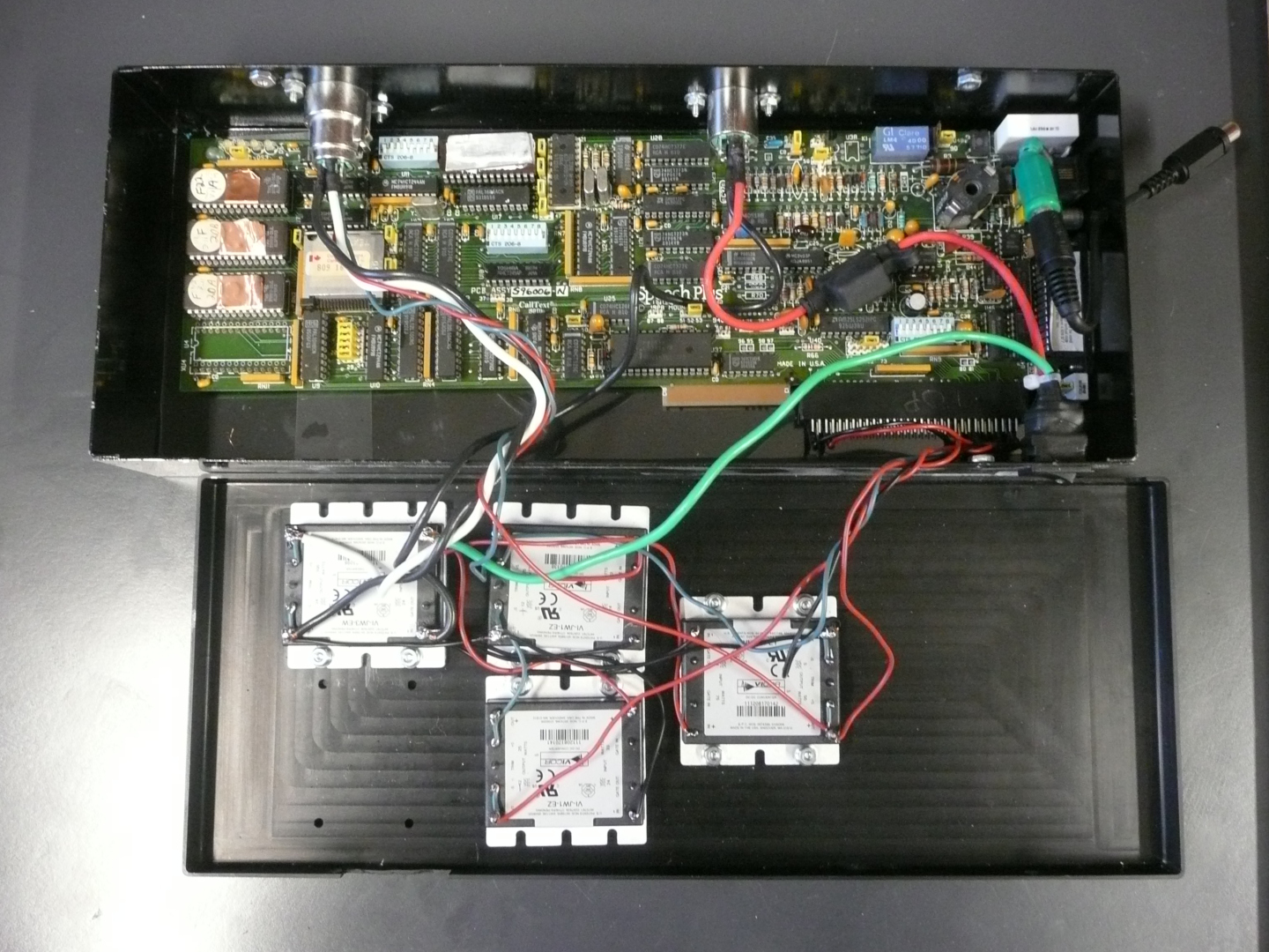 Speech Plus CallText 5010 voice synthesiser circuit board mounted in a metal chassis with an external power supply, showing the Intel 80188 CPU, DSP chip, ROM and RAM chips, and I/O interfaces.